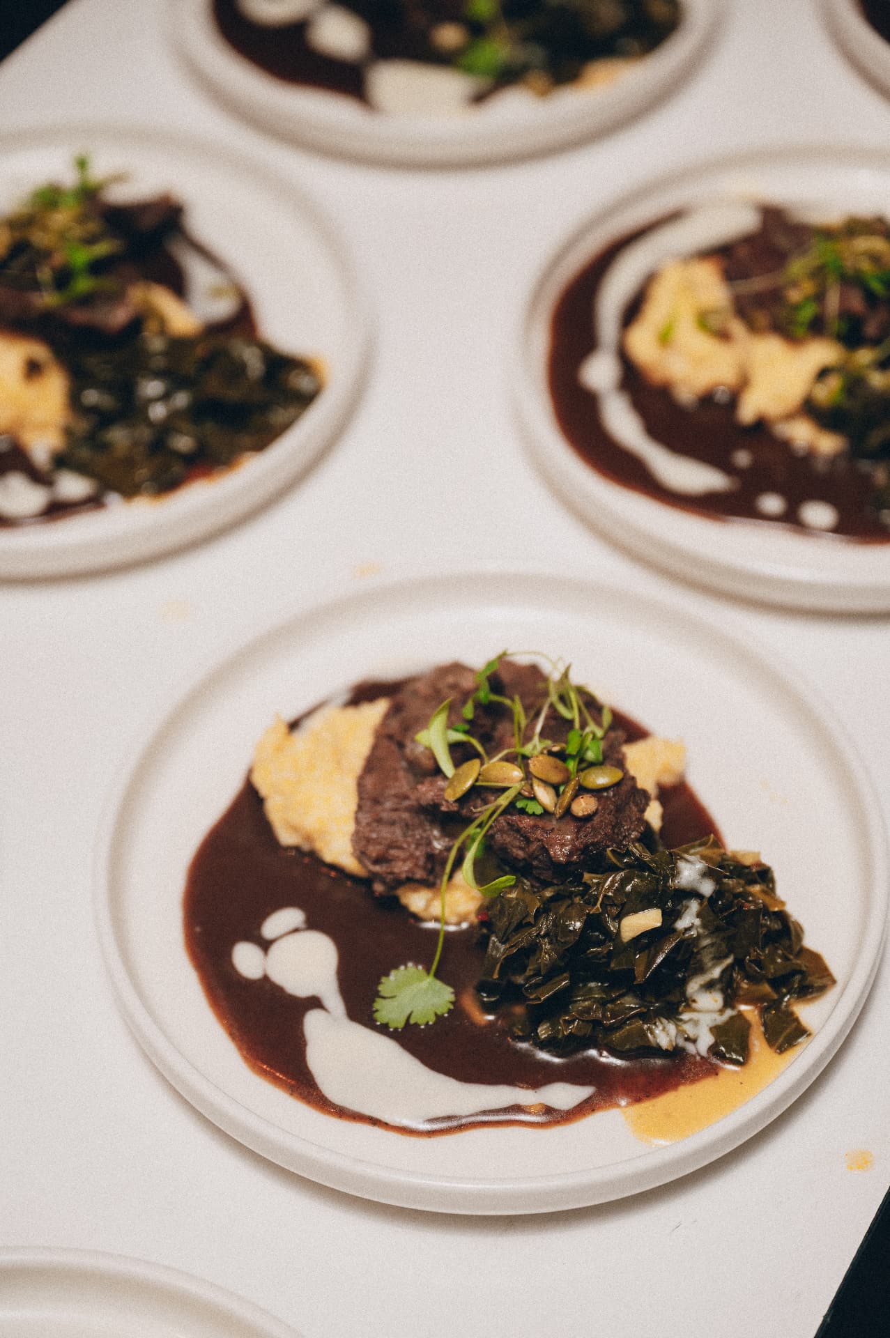 A plated course with braised greens and sauce